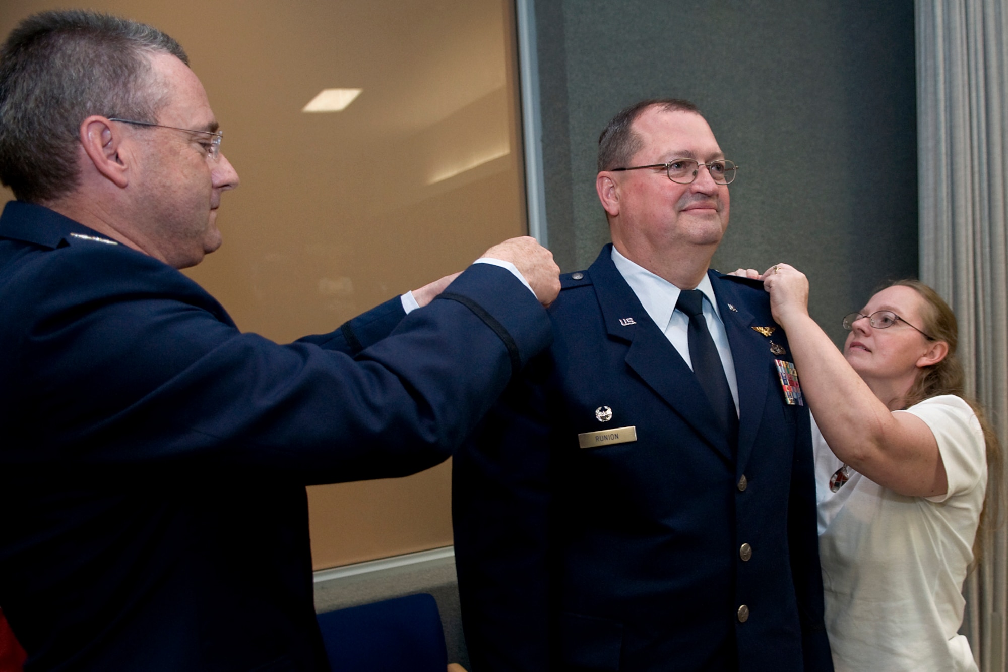 Col. Bryan Runion, 434th Logistics Readiness Squadron commander, center, has Col. Bryan Reinhart, 434th Air Refueling Wing vice commander, left, Runion's wife Diana pin colonel rank on him during a special ceremony at Grissom Air Reserve Base, Ind., June 7, 2014. Runion was recently promoted to the rank of colonel in front of family, friends and peers. (U.S. Air Force photo/Staff Sgt. Benjamin Mota)
