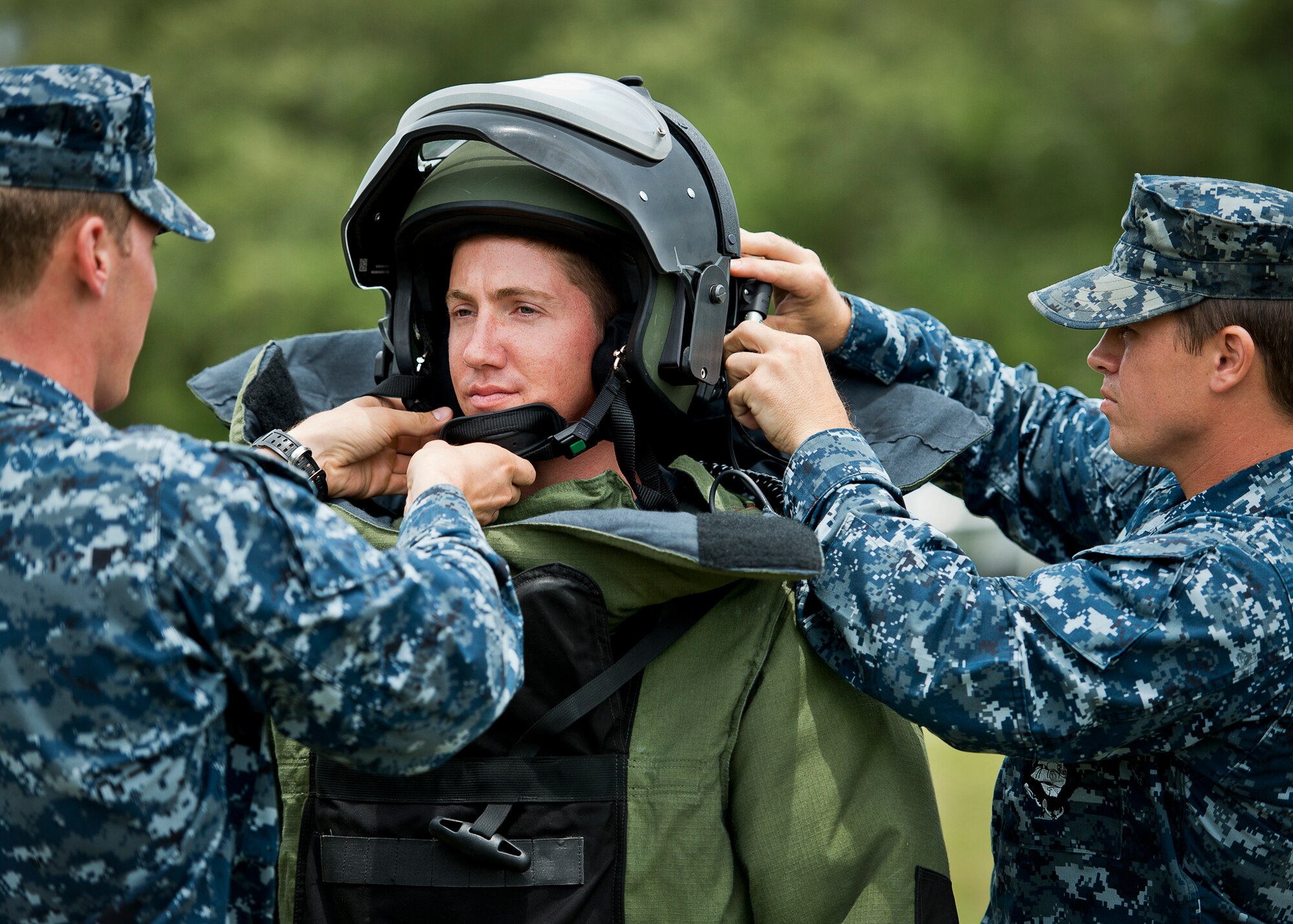 Navy explosive ordnance disposal students suit up their fellow Sailor in a bomb suit at Eglin Air Force Base, Fla.  After completing the standard DOD training course at Navy EOD school, Sailors attend the 55-day dive training on Eglin.  The Naval School EOD staff trains approximately 1,800 DOD military, civilian and international students annually.  (U.S. Air Force photo/Tech. Sgt. Samuel King Jr.)