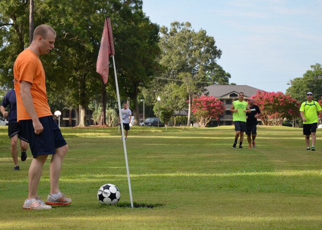 A team member kicks a soccer ball into the hole during a game of Battle
FootGolf at Wrenwoods Golf Course, July 11, 2014, at Joint Base Charleston, S.C. Similar to golf, each kick of the soccer ball is counted as a stroke. The Battle FootGolf was part of the monthly fitness challenge offered through the Air Base Fitness & Sports Center and is expected to become an annual event. (U.S. Air Force photo/Jessica Donnelly)
