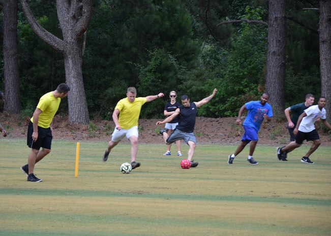 A pair of teams tee-off by kicking their soccer balls toward the green at the
Battle FootGolf at Wrenwoods Golf Course, July 11, 2014, at Joint Base Charleston, S.C. The Battle FootGolf was part of the monthly fitness challenge offered through
the Air Base Fitness & Sports Center and is expected to become an annual
event. FootGolf is a combination of soccer and golf where team members kick
a soccer ball into the marked holes on a golf course. (U.S. Air Force photo/Jessica
Donnelly)

