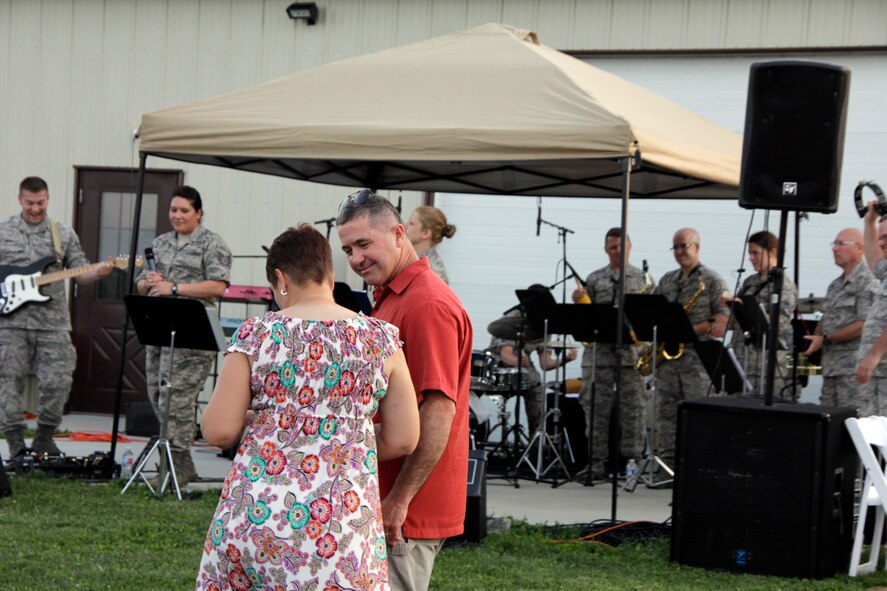 193rd Special Operations Wing Commander Col. John Dickinson, center, and his with Col. Colleen Dickinson dance to High Altitude, the rock band component of the Air National Guard Band of the Northeast during a performance at Cassell Vineyards of Hershey, Hummelstown, Pennsylvania, June 27, 2014. The Air National Guard Band of the Northeast is based out of Ft. Indiantown Gap, Pennsylvania and part of the 193rd Special Operations Wing. (U.S. Air National Guard photo by Tech. Sgt. Culeen Shaffer/Released)