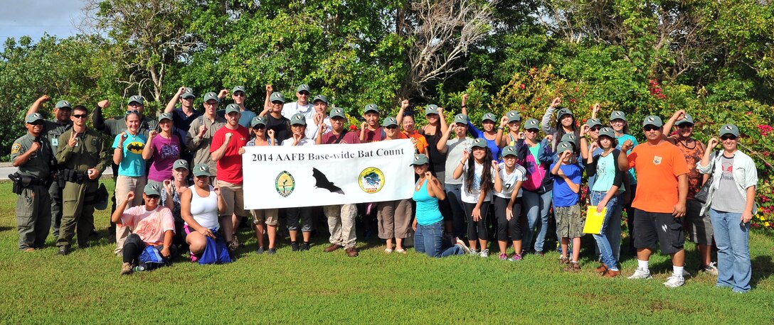 A portion of the volunteers hold up the number of Mariana fruit bats they saw on Andersen Air Force Base, Guam, July 3. More than 100 volunteers from the base and local community gathered for the first large-scale monitoring of the threatened species to help determine the population. (U.S. Air Force photo by Staff Sgt. Melissa B. White/Released)