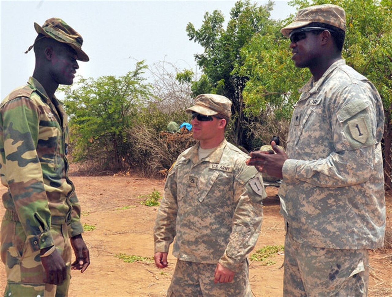 Army Spc. Lassana Traore, right, translates during a conversation between Army Pfc. Cody Anderson, center, and a Senegalese soldier during exercise Western Accord 14 at Camp Thies, Senegal, June 25, 2014. U.S. Army photo by Sgt. Takita Lawery