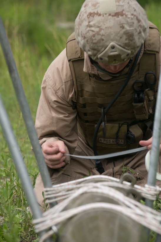 U.S. Marine Sgt. Randy Dube, a Lisbon, Maine, native, places tape around a fuse on an inert bomb during Exercise Dragon Crab, a three-day exercise, June 26 at the Rodriguez Live-Fire Complex, Republic of Korea. The procedure is called a tape and line, and enables explosive ordnance disposal technicians to take out the fuse from a safe distance. The scenario is one of eight meant to test the skills of EOD technicians from the U.S. Marine Corps and Army. Dube is an EOD technician with Marine Wing Support Squadron 172, Marine Wing Support Group 17, 1st Marine Aircraft Wing, III Marine Expeditionary Force. (U.S. Marine Photo by Lance Cpl. Abbey Perria/Released)