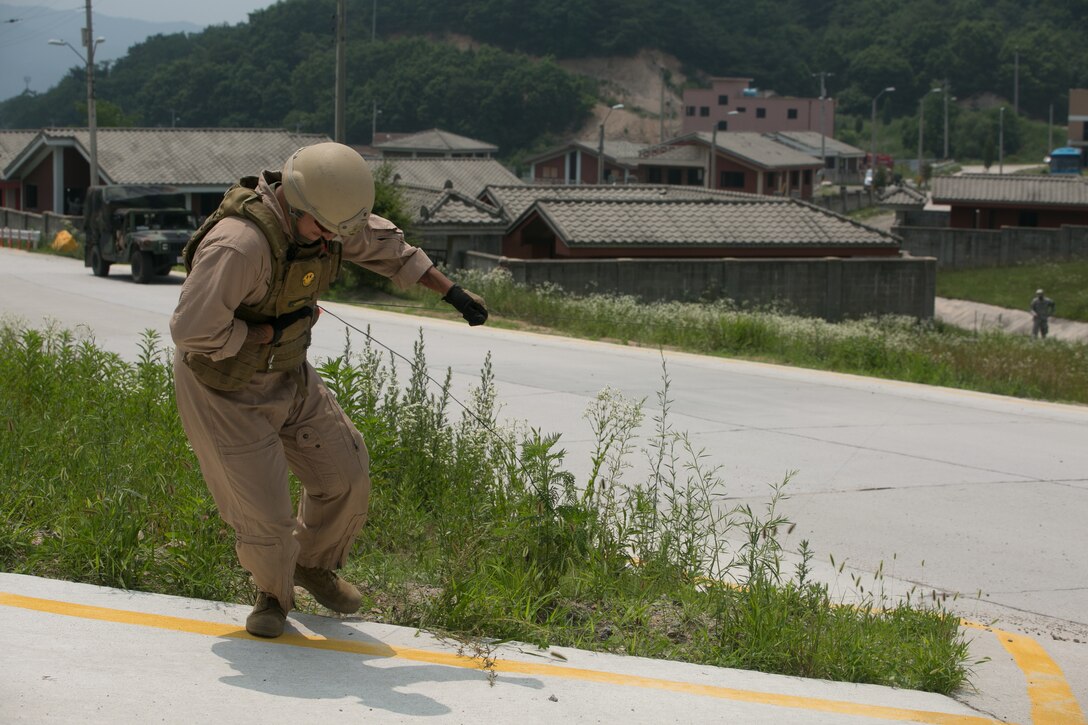 U.S. Marine Sgt. Jesus Contreras, a Fabens, Texas, native, yanks on a rope attached to a fuse to pull it out of an inert bomb during Exercise Dragon Crab, a three-day exercise, June 26 at the Rodriguez Live-Fire Complex, Republic of Korea. The procedure is called a tape and line, and enables explosive ordnance disposal technicians to defuse a bomb from a safe distance. The scenario is one of eight meant to test the skills of EOD technicians from the U.S. Marine Corps and Army. Contreras is an EOD technician with Marine Wing Support Squadron 172, Marine Wing Support Group 17, 1st Marine Aircraft Wing, III Marine Expeditionary Force. (U.S. Marine Photo by Lance Cpl. Abbey Perria/Released)