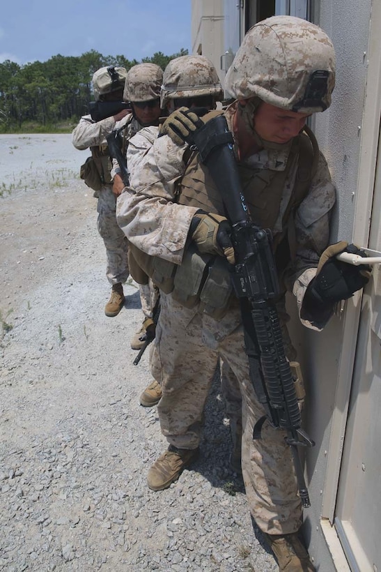 A team of Marines stack on a door in preparation to clear a mock hostile enemy compound during military operations on urban terrain training at Marine Corps Outlying Field Atlantic, N.C., July, 7-11, 2014. The Marines practiced room clearing techniques and communication skills to prepare for an upcoming deployment. The Marines are with 2nd Low Altitude Air Defense Battalion.