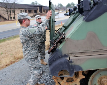 GED Plus graduate Army Pvt. Daniel Houten (front) and Army Sgt. 1st Class Jerry Bowling (rear), mortarman course manager, Arkansas Army National Guard's 233rd Regional Training Institute, fold down the armored plate protecting the engine compartment of a M106 mortar carrier at Camp J.T. Robinson in North Little Rock, Ark. Houten, a former Israel Defense Forces M113 armored personnel carrier mechanic, checked out this similar American version with enthusiasm. After his service in Israel was complete, Houten enlisted in the Georgia Army National Guard and is currently in Army basic training at Ft. Benning, Ga.