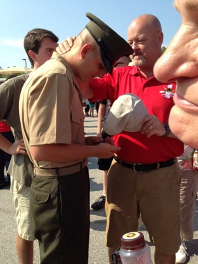 Private Daniel Pritchett, recent graduate of Bravo Company, 1st Battalion, admires a coin and ring given to him from his dad Kenneth Pritchett on June 20, 2014 at Marine Corps Recruit Depot Parris Island. Both son and father can now be called United States Marines.