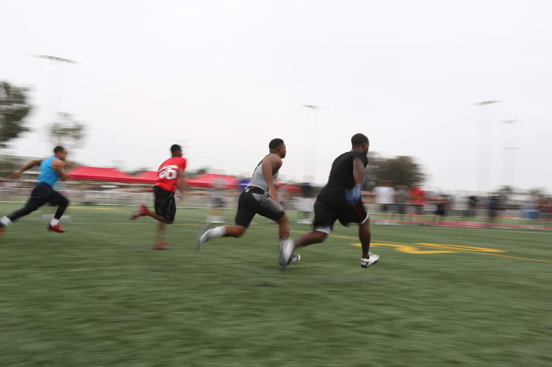 Darren Sproles, right, Philadelphia Eagles running back, sprints with Marines during the NFL Football Star Experience aboard Marine Corps Air Station Miramar, Calif., July 15. The NFL Football Star Experience included additional drills, such as pass-and-throw drills and various agility drills. 