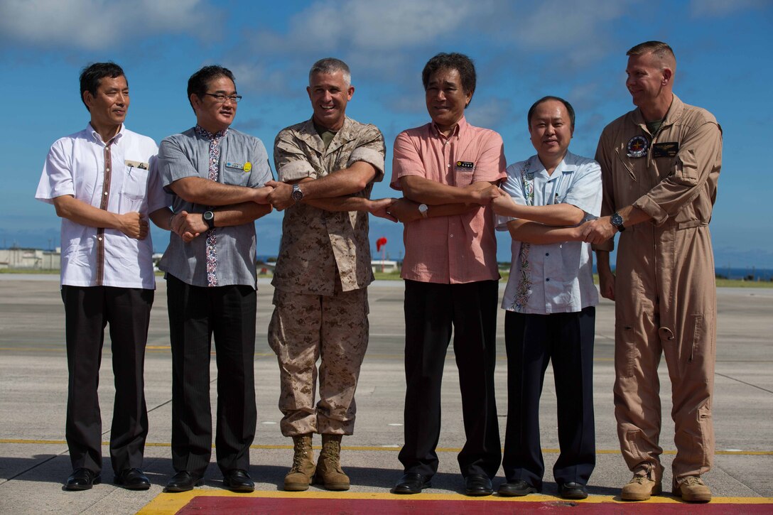 From left to right, Toshihisa Takata, Atsushi Sakima, Brig. Gen. Paul J. Kennedy, Vice Gov. Kurayoshi Takara, Hirofumi Takida and Lt. Col. Matthew W. Stover shake hands July 15 at Marine Corps Air Station Futenma during the squadron’s take off ceremony. The ceremony commemorates the beginning of VMGR-152’s transfer to MCAS Iwakuni. Takata is the ambassador in charge of Okinawan Affairs, Ministry of Foreign Affairs of Japan. Sakima is the mayor of Ginowan City. Kennedy is the deputy commanding general of III Marine Expeditionary Force and commanding general of 3rd Marine Expeditionary Brigade. Takara is the vice governor of Okinawa prefecture. Takida is the Director General of the Okinawa Defense Bureau. Stover is the commanding officer of VMGR-152, Marine Aircraft Group 36, 1st Marine Aircraft Wing, III MEF. (U.S. Marine Corps photo by Cpl. Natalie M. Rostran/Released)