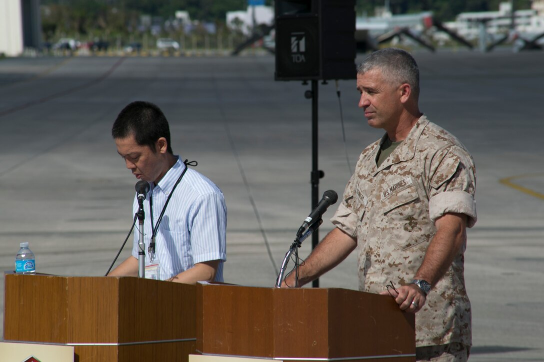 Brig. Gen. Paul J. Kennedy, right, addresses an audience through a translator July 15 on Marine Corps Air Station Futenma during Marine Aerial Refueler Transport Squadron 152’s take off ceremony. The ceremony commemorates the beginning of VMGR-152’s transfer to MCAS Iwakuni as part of the Marine Corps and Government of Japan’s bilateral effort to reduce impact to communities around MCAS Futenma, realign the presence and distribute the activities of U.S. forces in Japan. Kennedy is the deputy commanding general of III MEF and commanding general of 3rd Marine Expeditionary Brigade. VMGR-152 is with Marine Aircraft Group 36, 1st Marine Aircraft Wing, III MEF. (U.S. Marine Corps photo by Lance Cpl. Pete Sanders/Released)