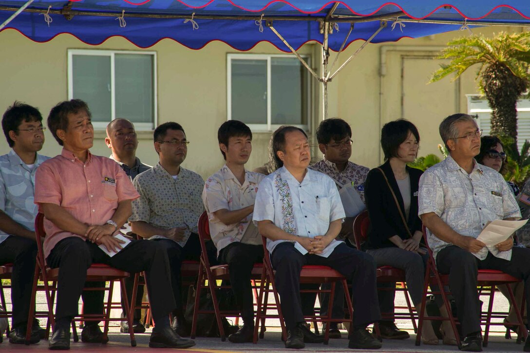 Vice Gov. Kurayoshi Takara, front row left, and Hirofumi Takeda, front row center, listen to remarks July 15 on Marine Corps Air Station Futenma during Marine Aerial Refueler Transport Squadron 152’s take off ceremony. The ceremony commemorates the beginning of VMGR-152’s transfer to MCAS Iwakuni as part of the Marine Corps and Government of Japan’s bilateral effort to reduce impact to communities surrounding MCAS Futenma, realign the presence and distribute the activities of U.S. forces in Japan. Takara is the vice governor of Okinawa prefecture. Takeda is the Director General of the Okinawa Defense Bureau. VMGR-152 is with Marine Aircraft Group 36, 1st Marine Aircraft Wing, III Marine Expeditionary Force. (U.S. Marine Corps photo by Lance Cpl. Pete Sanders/Released)