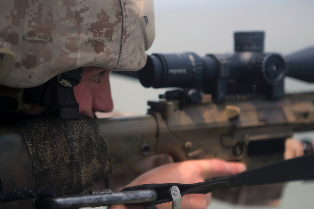 Cpl. Phillip S. Lilly II, a scout sniper with the 24th Marine Expeditionary Unit’s Ground Combat Element, Battalion Landing Team 3rd Battalion, 6th Marine Regiment, and a Princewick, W.V., native, sites in on a rifle scope during a Visit, Board, Search, and Seizure exercise at Joint Base Langley-Eustis, Va., July 15, 2014. During VBSS, scout snipers provided cover from UH-1Y Hueys to the Maritime Raid Force, Force Reconnaissance Company, 2nd Reconnaissance Battalion on the simulated vessel of interest.  The Hueys are part of the organic air assets of the 24th Marine Expeditionary Unit’s Aviation Combat Element, Marine Medium Tiltrotor Squadron 365 (Reinforced). The exercise is part of Realistic Urban Training and is the first major pre-deployment training exercise for the 24th MEU in preparation for their deployment later this year. (U.S. Marine Corps photo by Cpl. Devin Nichols)