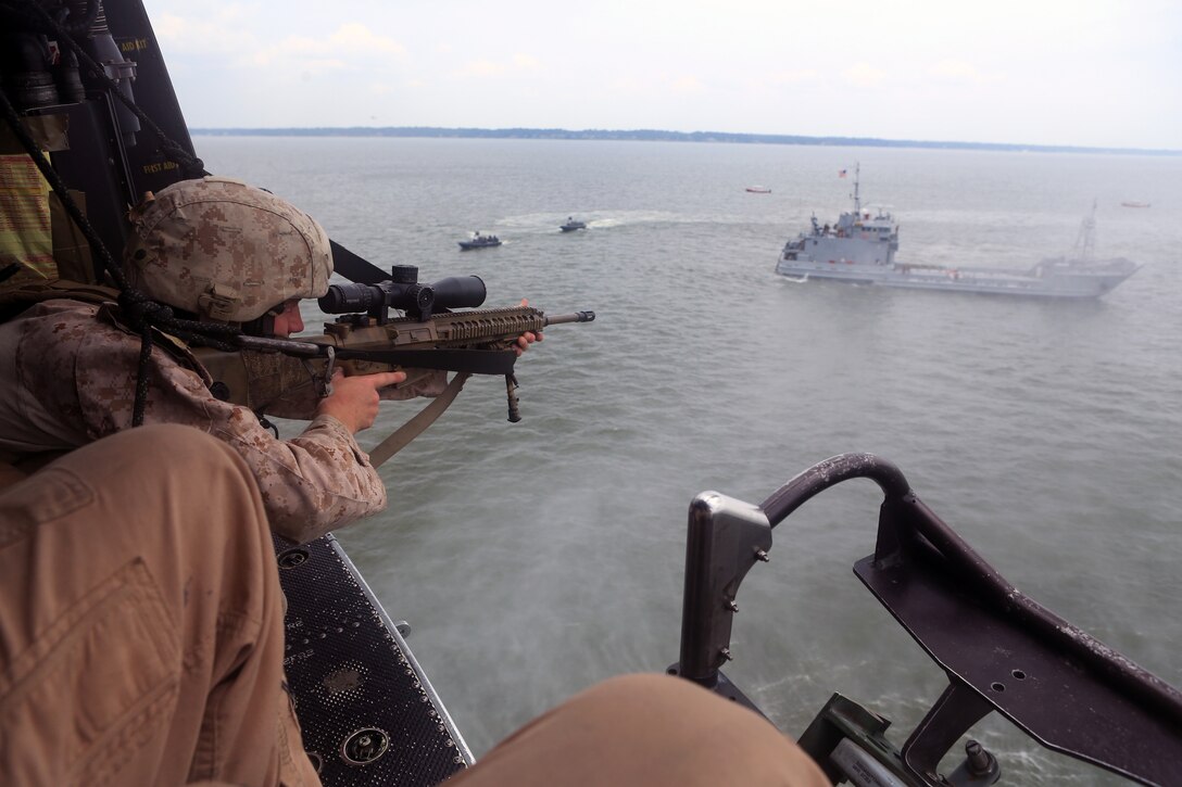 Cpl. Phillip S. Lilly II, a scout sniper with the 24th Marine Expeditionary Unit’s Ground Combat Element, Battalion Landing Team 3rd Battalion, 6th Marine Regiment, and a Princewick, W.V., native, sites in with his rifle from a UH-1Y Huey during a Visit, Board, Search, and Seizure exercise at Joint Base Langley-Eustis, Va., July 15, 2014. During VBSS, scout snipers provided cover from aircraft to the Maritime Raid Force, Force Reconnaissance Company, 2nd Reconnaissance Battalion on the simulated vessel of interest.  The Hueys are part of the organic air assets of the 24th Marine Expeditionary Unit’s Aviation Combat Element, Marine Medium Tiltrotor Squadron 365 (Reinforced). The exercise is part of Realistic Urban Training and is the first major pre-deployment training exercise for the 24th MEU in preparation for their deployment later this year. (U.S. Marine Corps photo by Cpl. Devin Nichols)