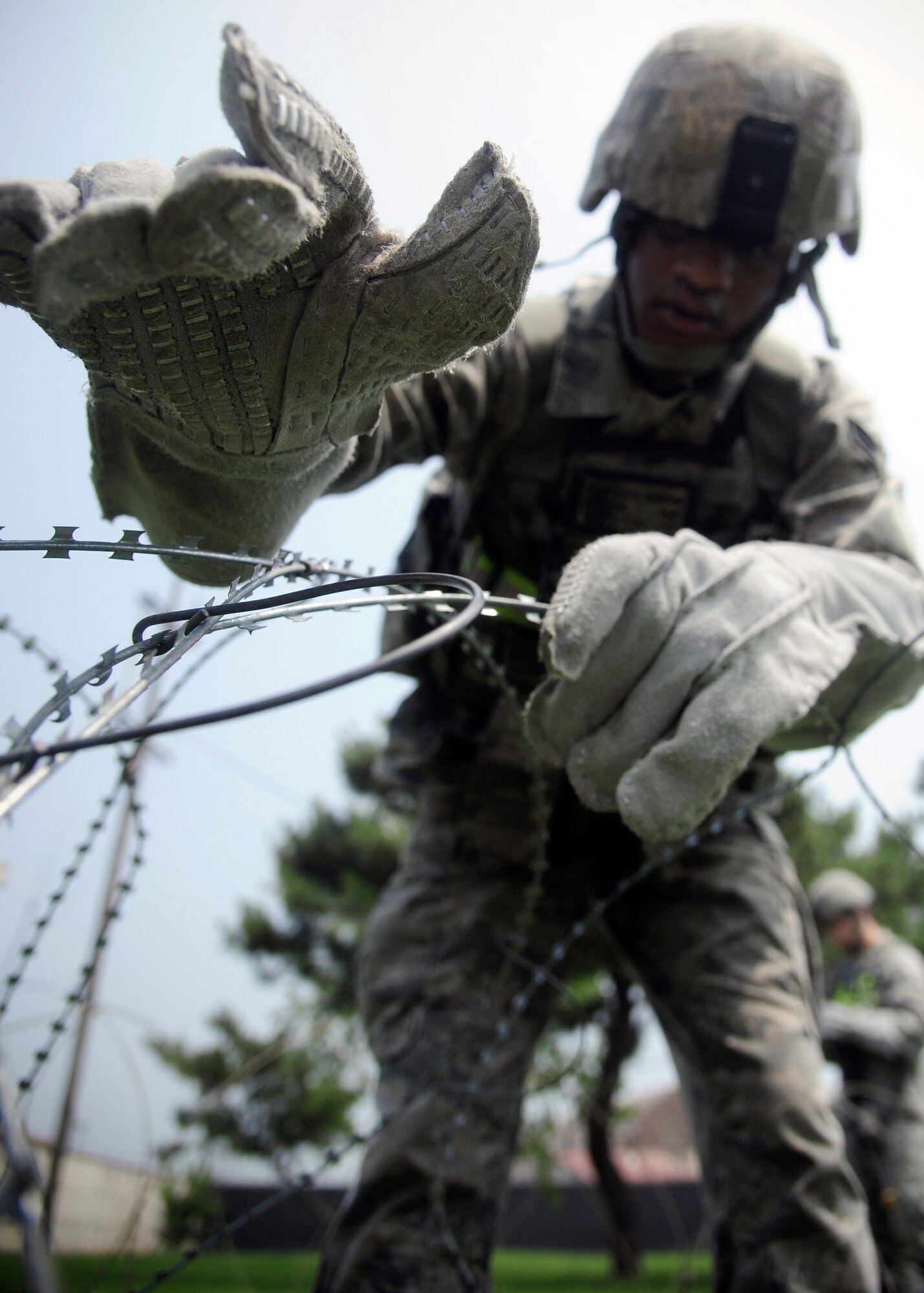 Airman 1st Class Jonathan Fultz, 8th Security Forces Squadron installation patrolman, stretches concertina wire during exercise Beverly Midnight 14-2 at Kunsan Air Base, Republic of Korea, July 14, 2014.  The Operational Readiness Exercise assesses mission capabilities and ensures the Wolf Pack is in a constant state of readiness. (U.S. Air Force photo by Senior Airman Taylor Curry/Released) 