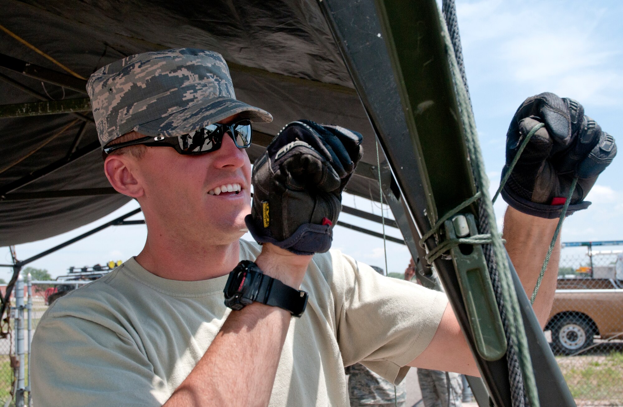 Staff Sgt. Riley Enberg, 90th Civil Engineers Squadron, tightens ropes on a tent July 14, 2014, in preparation for Fort DA Russell. The 90th CES is responsible for setting up tents, placing signs to guide visitors to the base and setting up snow fences in preparation for Fort D.A. Russell Days, an event that occurs here annually. (U.S. Air Force photo by Airman Malcolm Mayfield)