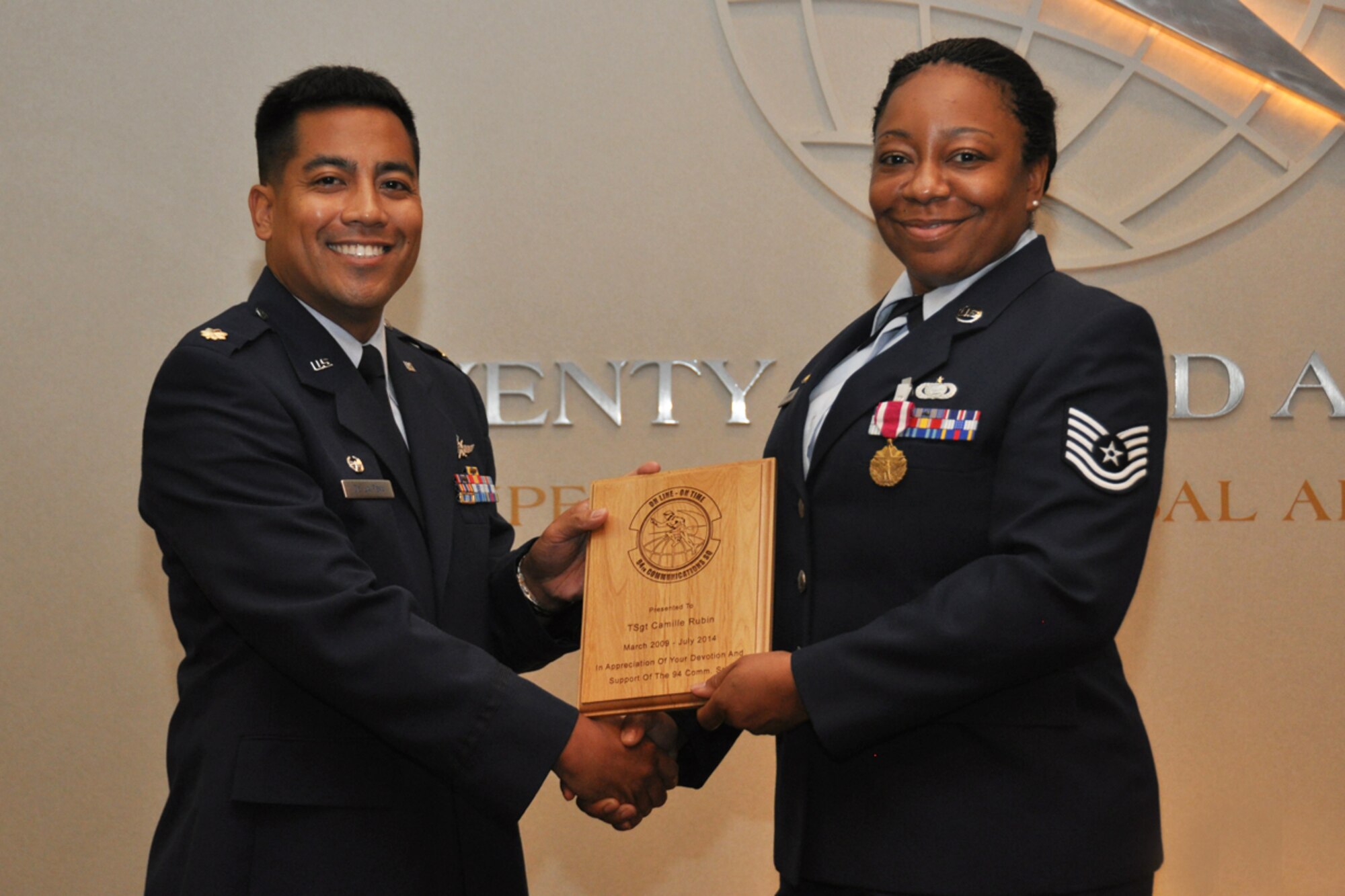 Maj. Jamison De La Peña, former 94th Communications Squadron commander, presents a token of appreciation on behalf of the squadron to Tech. Sgt. Marla Camille Rubin during her retirement ceremony June 24, 2014. Rubin was recognized for 20 years of military service. (U.S. Air Force photo/Staff Sgt. Karla Lehman)