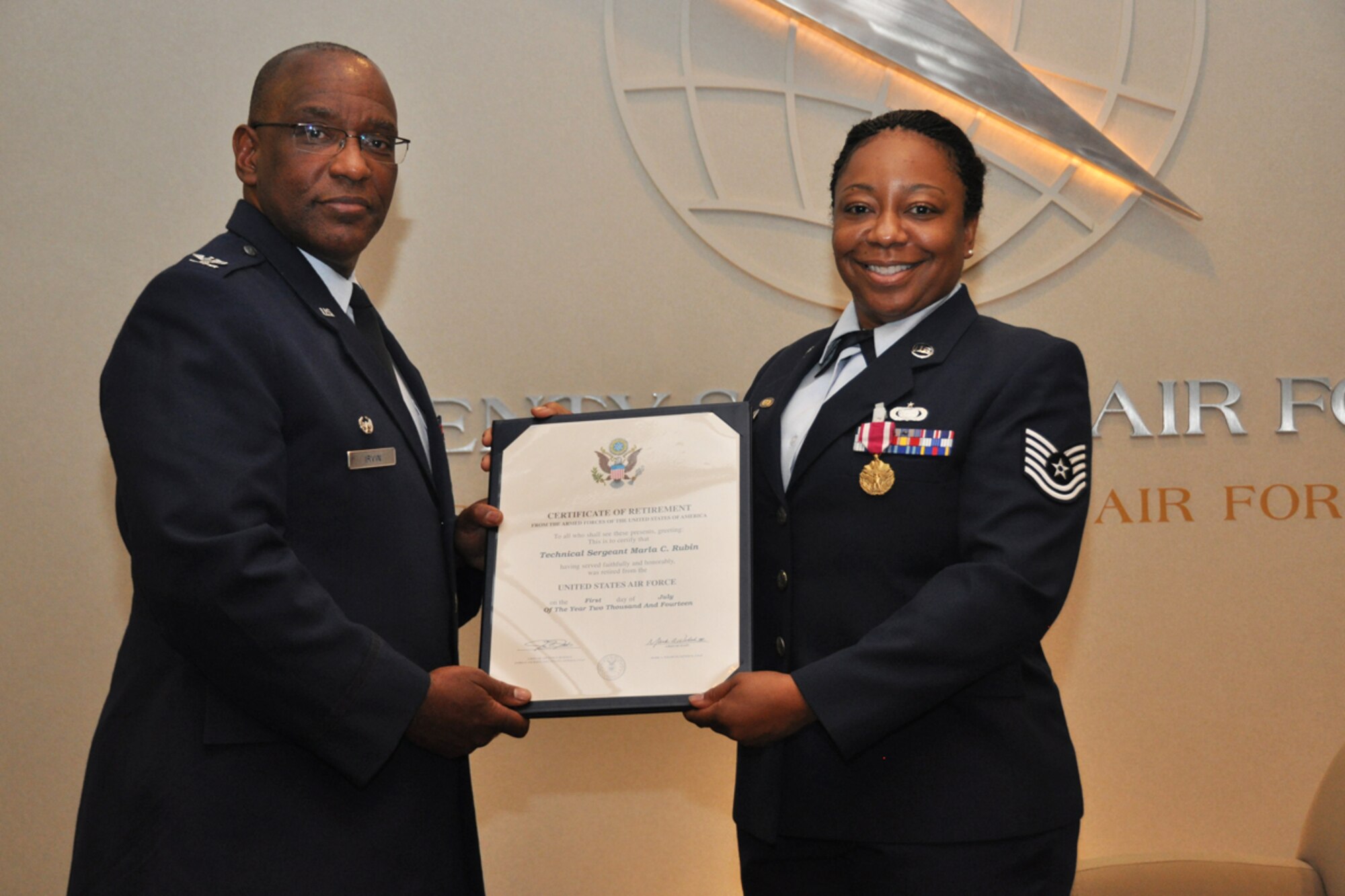 Col. Marshall Irvin, 94th Mission Support Group commander, presents a Certificate of Retirement to Tech. Sgt. Marla Camille Rubin of the 94th Communications Squadron during her retirement ceremony June 24, 2014. Rubin was recognized for 20 years of military service. (U.S. Air Force photo/Staff Sgt. Karla Lehman)