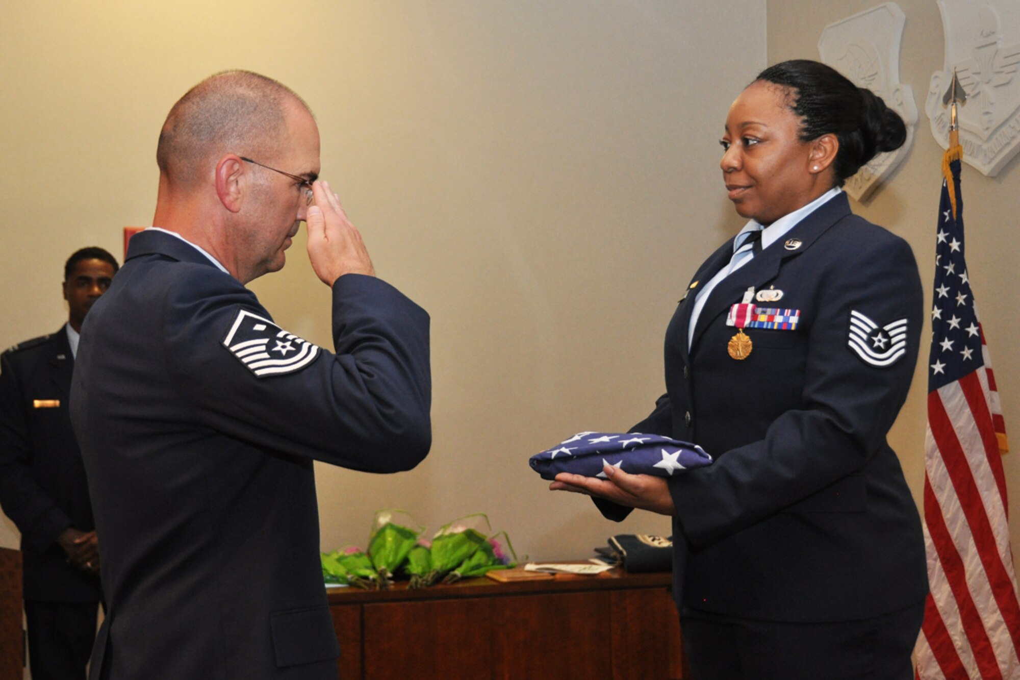Master Sgt. George Curry, 94th Communications Squadron first sergeant, presents the U.S. Flag to Tech. Sgt. Marla Camille Rubin during her retirement ceremony June 24, 2014. Rubin was recognized for 20 years of military service. (U.S. Air Force photo/Staff Sgt. Karla Lehman)