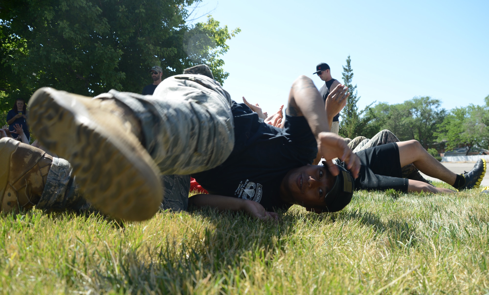 A person participating in the GORUCK Light Challenge July 12, 2014, slides off the bridge of hands which were supporting him at Mountain Home Air Force Base, Idaho. A key to the GORUCK Light challenge is how quickly participants are able to adapt to the obstacles and trust their teammates, for example when laying down on the arms of your team members and then being carried a big distance. (U.S. Air Force photo by Senior Airman Benjamin Sutton/Released)