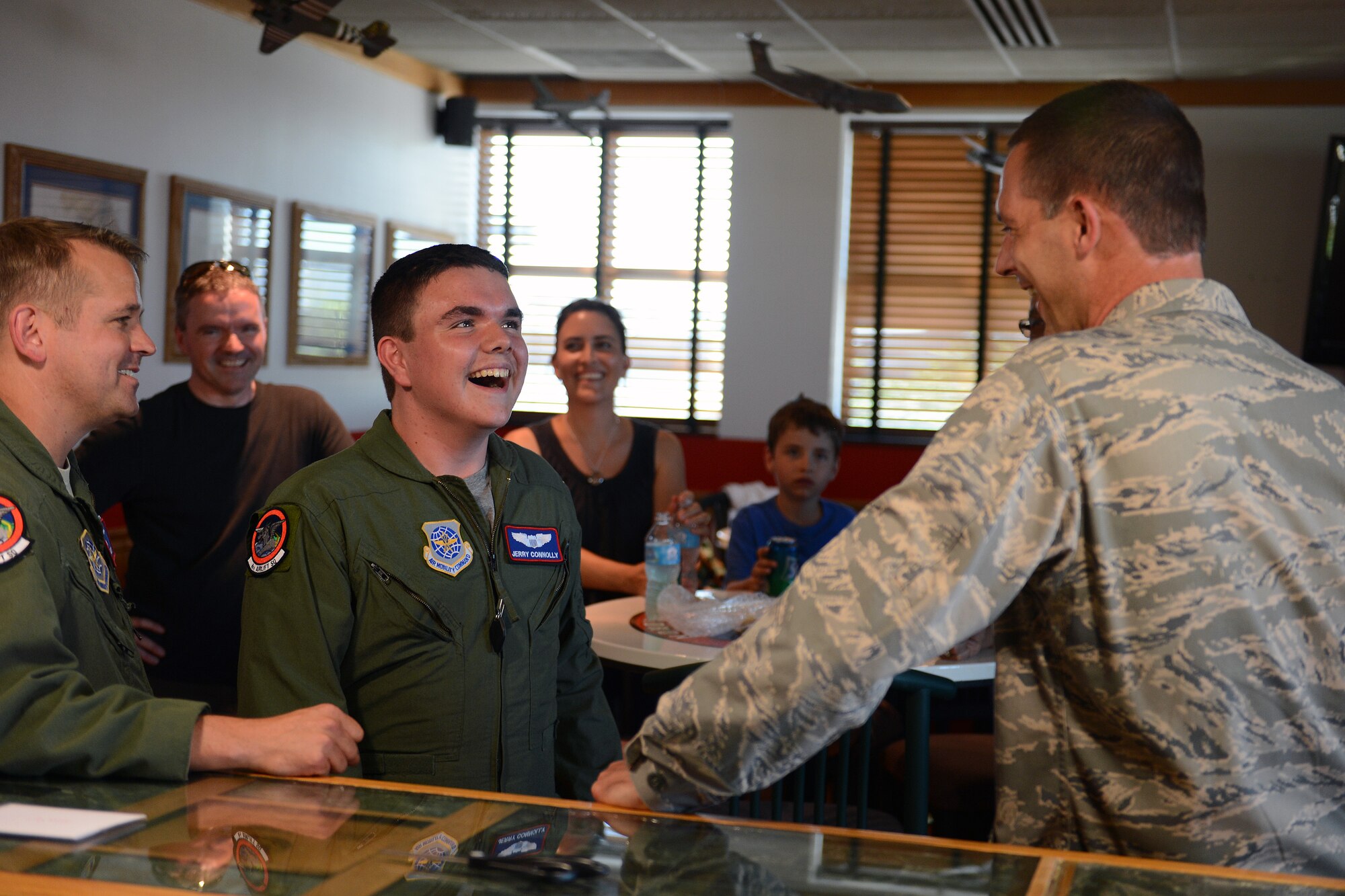 Lt. Col. Matt Anderson(left), 4th Airlift Squadron commander, and Jerry Connolly(center), pilot for a day, tell Col. Ethan Griffin, 62nd Airlift Wing vice commander, about the events that took place during the pilot for a day July 14, 2014, at Joint Base Lewis-McChord, Wash. Griffin presented Connolly with a commander’s coin during his farewell party put on by the 4th AS. (U.S. Air Force photo/Airman 1st Class Jacob Jimenez)  