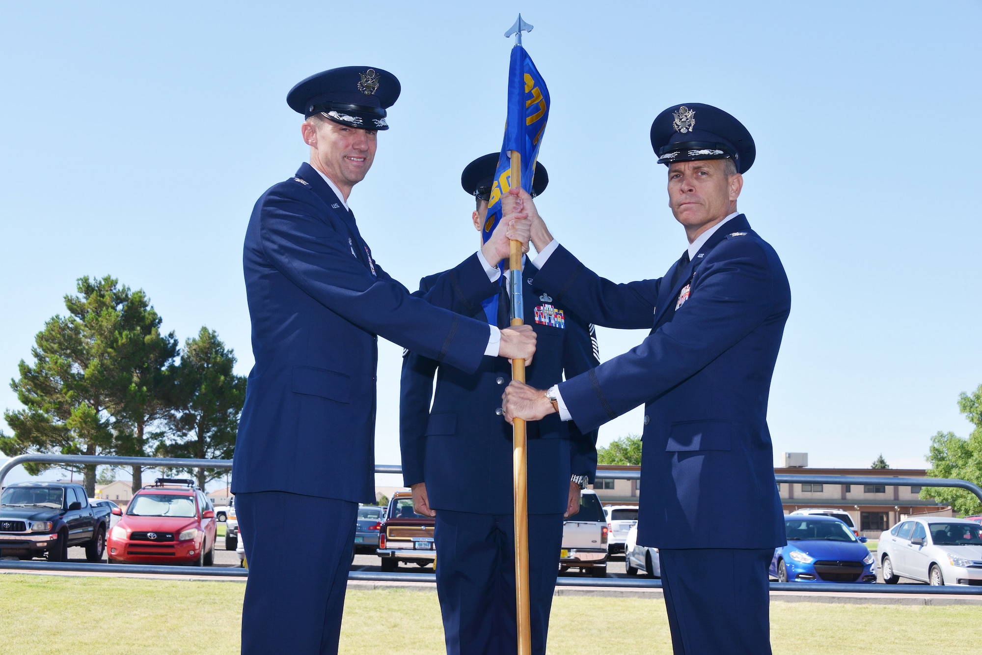 Col. Tom Miller (left), 377th Air Base Wing commander, passes the guidon to Col. Dennis A. Haught, new 377th Mission Support Group commander at a change of commander ceremony July 11.  Col. Jeffrey Lanning relinquished command at the ceremony.  (Photo by Todd Berenger)