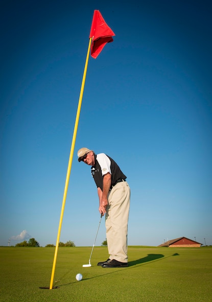 Jerry Brown, manager of the Rough Rider Golf Course, demonstrates proper putting technique on Minot Air Force Base, N.D., July 14, 2014. Brown has approximately 31 years of experience golfing and hopes to instill the love of the sport in others who want to learn. (U.S. Air Force photo/Airman 1st Class Sahara L. Fales)