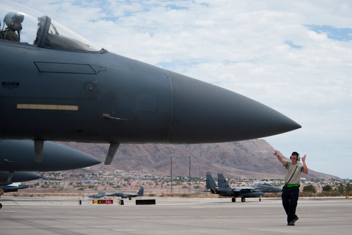 Airman 1st Class Ryan Merritt, 335th Aircraft Maintenance Unit crew chief, Seymour Johnson Air Force Base, N.C. marshals an F-15E Strike Eagle during Red Flag 14-3 July 14, 2014, Nellis AFB, Nev.  The U.S. Air Force’s premier exercise provides aircrews and ground crews the opportunity to experience realistic, stressful combat situations in a controlled environment to increase their ability to complete missions and return home (U.S. Air Force photo by Lawrence Crespo) 