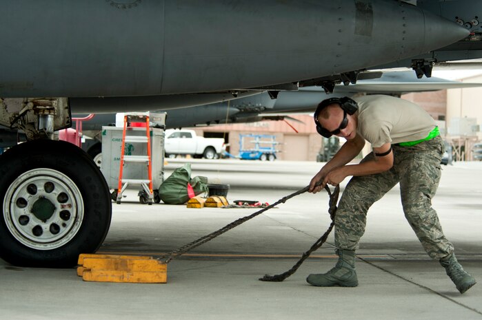 Airman 1st Class Michael Brabson, 335th Aircraft Maintenance Unit crew chief, pulls the chocks from an F-15E Strike Eagle, assigned to the 335th Fighter Squadron, during Red Flag 14-3 July 14, 2014, at Nellis Air Force Base, Nev. The exercise is hosted north of Las Vegas on the Nevada Test and Training Range -- the U.S. Air Force's premier military training area with more than 15,000 square miles of airspace and 2.9 million acres of land. (U.S. Air Force photo by Senior Airman Timothy Young)