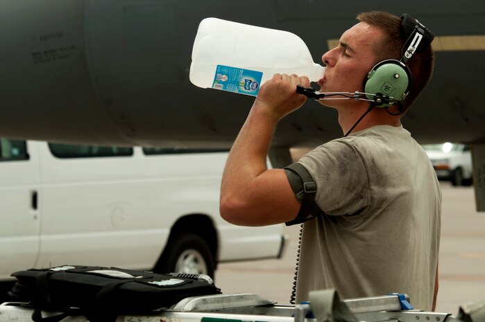 Airman 1st Class Ryan Merritt, 335th Aircraft Maintenance Unit crew chief, takes a moment to hydrate while assisting pilots to prepare for takeoff during Red Flag 14-3 July 14, 2014, at Nellis Air Force Base, Nev. Red Flag is a realistic combat training exercise involving the air, space, and cyber forces of the United States and its allies. (U.S. Air Force photo by Senior Airman Timothy Young)
