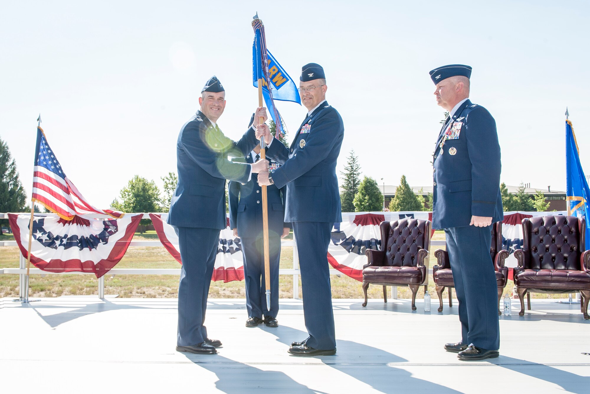 Col. Brian Newberry hands the guidon to Col. David Stookey during the 92nd Mission Support Group change of command ceremony at Fairchild Air Force Base, Washington, July 11, 2014. Col. Konrad Klausner steps down as the 92nd MSG commander as Col. David Stookey steps into the role. Stookey comes to Fairchild after serving for more than two years as the deputy director for information technology transformation at the Joint Staff Directorate from Command, Control, Communications Computers and Cyber. Klausner heads for the Headquarters U.S. Air Force in District of Columbia to serve as the chief of Global Mobility Division, Directorate of Operations, Deputy Chief of Staff for Operations, Plans and Requirements. The change of command ceremony is a tradition that represents a formal transfer of authority and responsibility. Newberry is the 92nd Air Refueling Wing commander. (U.S. Air Force photo by Staff Sgt. Benjamin W. Stratton/Released)