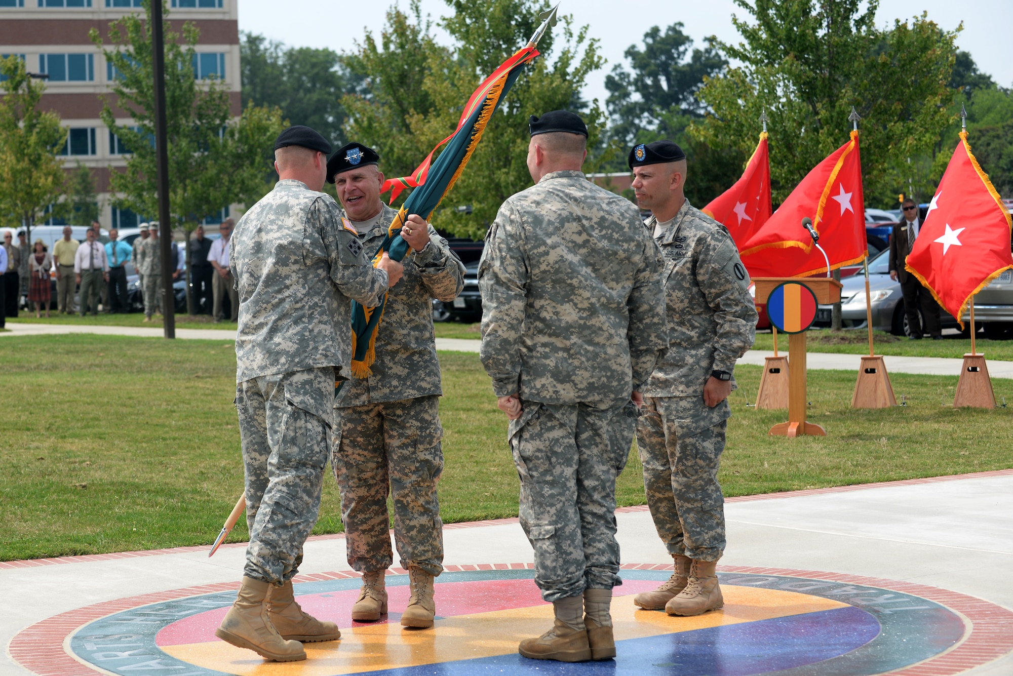 U.S. Army Gen. David G. Perkins, Army Training and Doctrine Command commanding general, passes the unit colors to Lt. Gen. H. R. McMaster, incoming Army Capabilities Integration Center commander, during the TRADOC ARCIC assumption of responsibility ceremony at Fort Eustis, Va., July 15, 2014. The transfer of the colors represents the transfer of responsibility for the accomplishment of the mission, and for providing for the welfare, order and discipline of the Soldiers assigned. (U.S. Air Force photo by Senior Airman Teresa J.C. Aber/Released) 