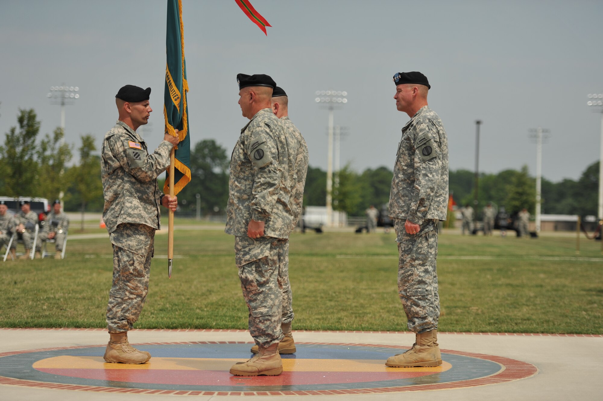 U.S. Army Sgt. Maj. Joe B. Parson, incoming Army Training and Doctrine Command Army Capabilities Integration Center command sergeant major, left, prepares to exchange unit colors during the TRADOC ARCIC assumption of responsibility ceremony at Fort Eustis, Va., July 15, 2014.  Parson most recently served as the Army Combined Arms Center command sergeant major, and assumed responsibility of ARCIC along with Lt. Gen. H. R. McMaster, second from left.  (U.S Air Force photo by Staff Sgt. Katie Gar Ward/Released)
