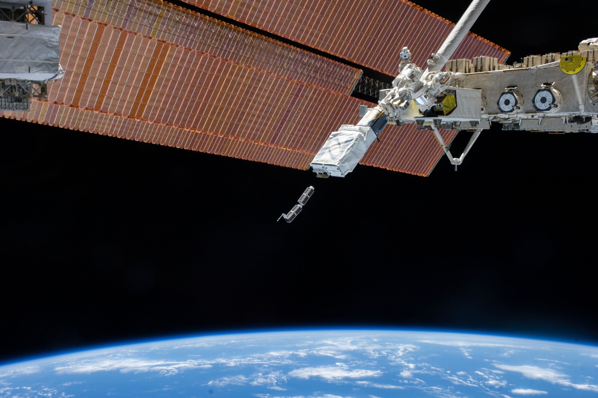 Miniature satellites, called CubeSats, are deployed from a much larger satellite. (NASA photo)