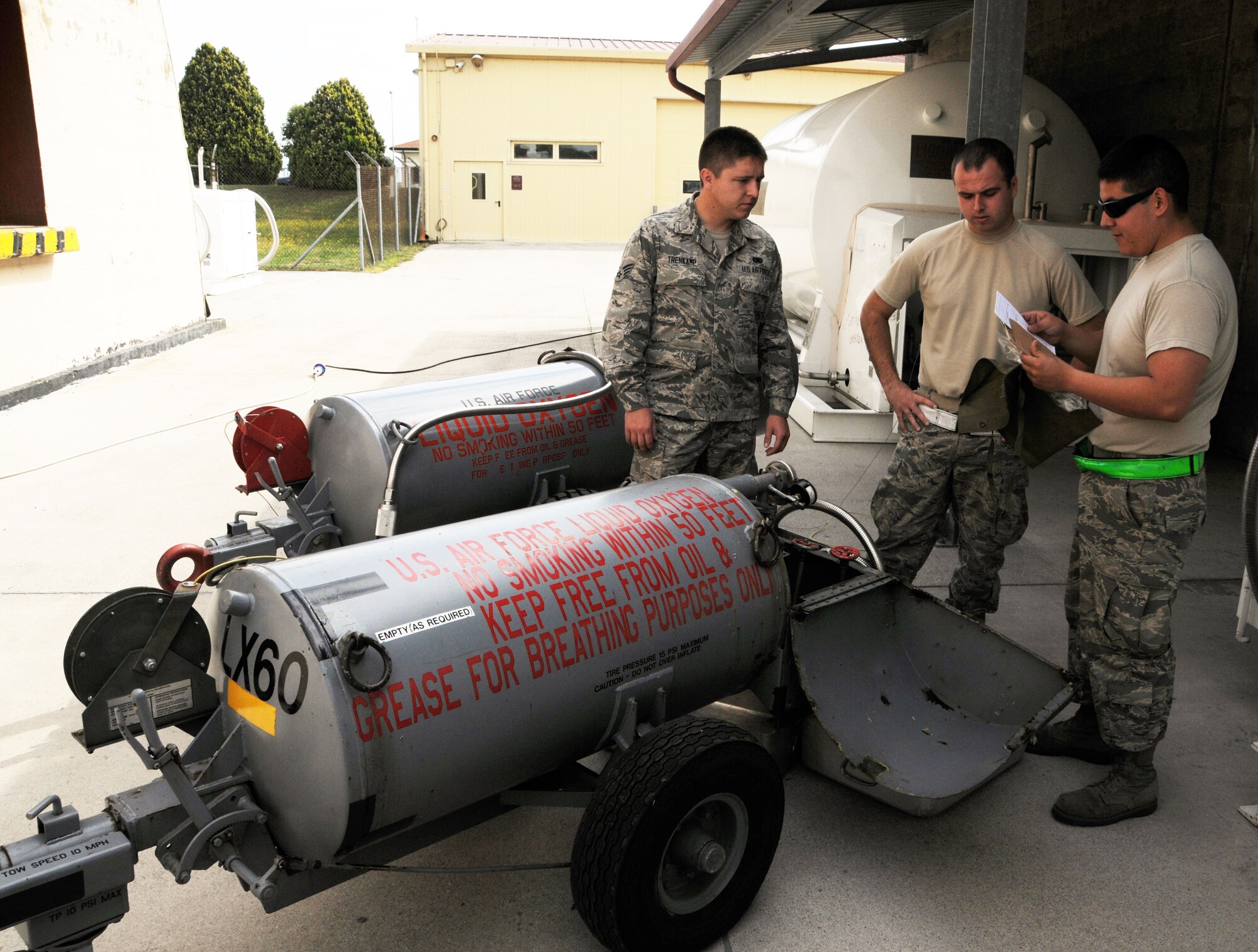 AVIANO AIR BASE, Italy - Senior Airmen Darren TrenKamp and Andrew Wade, 445th Logistics Readiness Squadron cryogenics lab, and Senior Airman Lenny Guzman (right), 31st Fighter Wing Logistics Readiness Squadron, review a checklist prior to filling a liquid oxygen cart. Reservists from the 445th LRS left June 13, 2014 to spend two weeks performing their annual tour at Aviano Air Base, Italy. The men and women spent the time working with their counterparts from the 31st FW. They assisted with day-to-day duties and received valuable training.  (U.S. Air Force photo/Tech. Sgt. Anthony Springer)