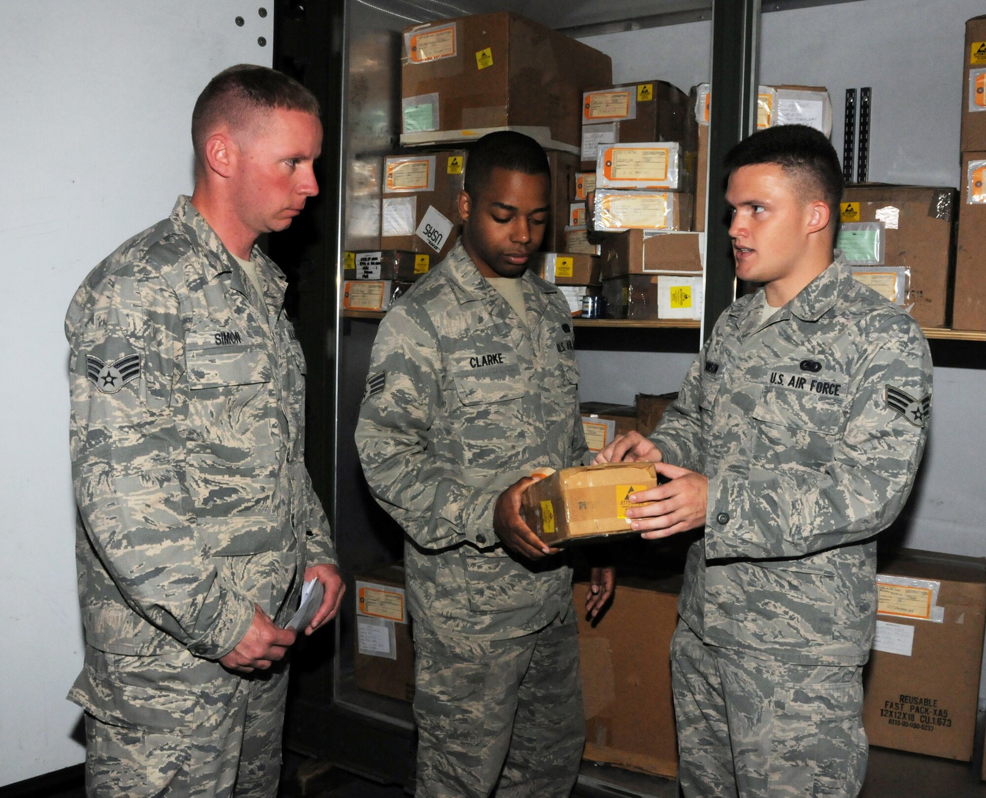 AVIANO AIR BASE, Italy - Senior Airman Justin Edmonson (right), 31st Fighter Wing Logistics Readiness Squadron, explains proper labeling of stock items to Senior Airmen Zack Simon and Jermaine Clarke, 445th Logistics Readiness Squadron materials management section. Reservists from the 445th LRS left June 13, 2014 to spend two weeks performing their annual tour at Aviano Air Base, Italy. The men and women spent the time working with their counterparts from the 31st FW. They assisted with day-to-day duties and received valuable training.  (U.S. Air Force photo/Tech. Sgt. Anthony Springer)