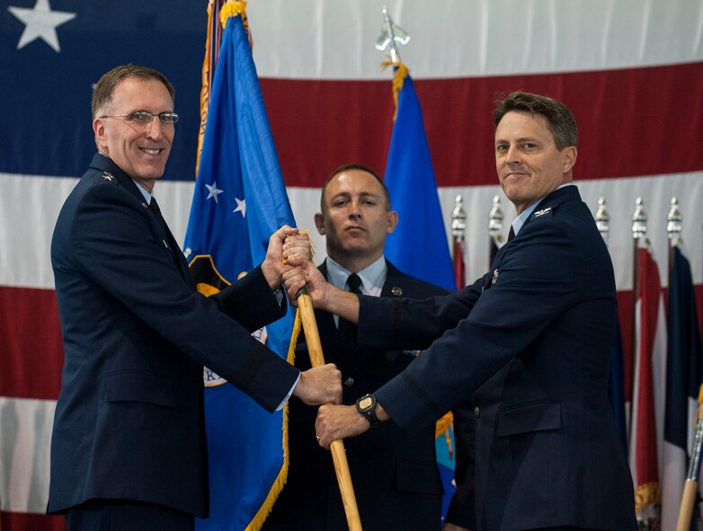 (from left to right) Maj. Gen. Scott Vander Hamm, 8th Air Force commander, hands the 5th Bomb Wing guide-on to Col. Jason Armagost, signifying his transition to command of the wing during the 5th BW Change of Command ceremony on Minot Air Force Base, N.D., July 14, 2014. The 5th BW includes a total force of approximately 3,800 military members as well as 587 civilian employees. (U.S. Air Force photo/Senior Airman Stephanie Morris)