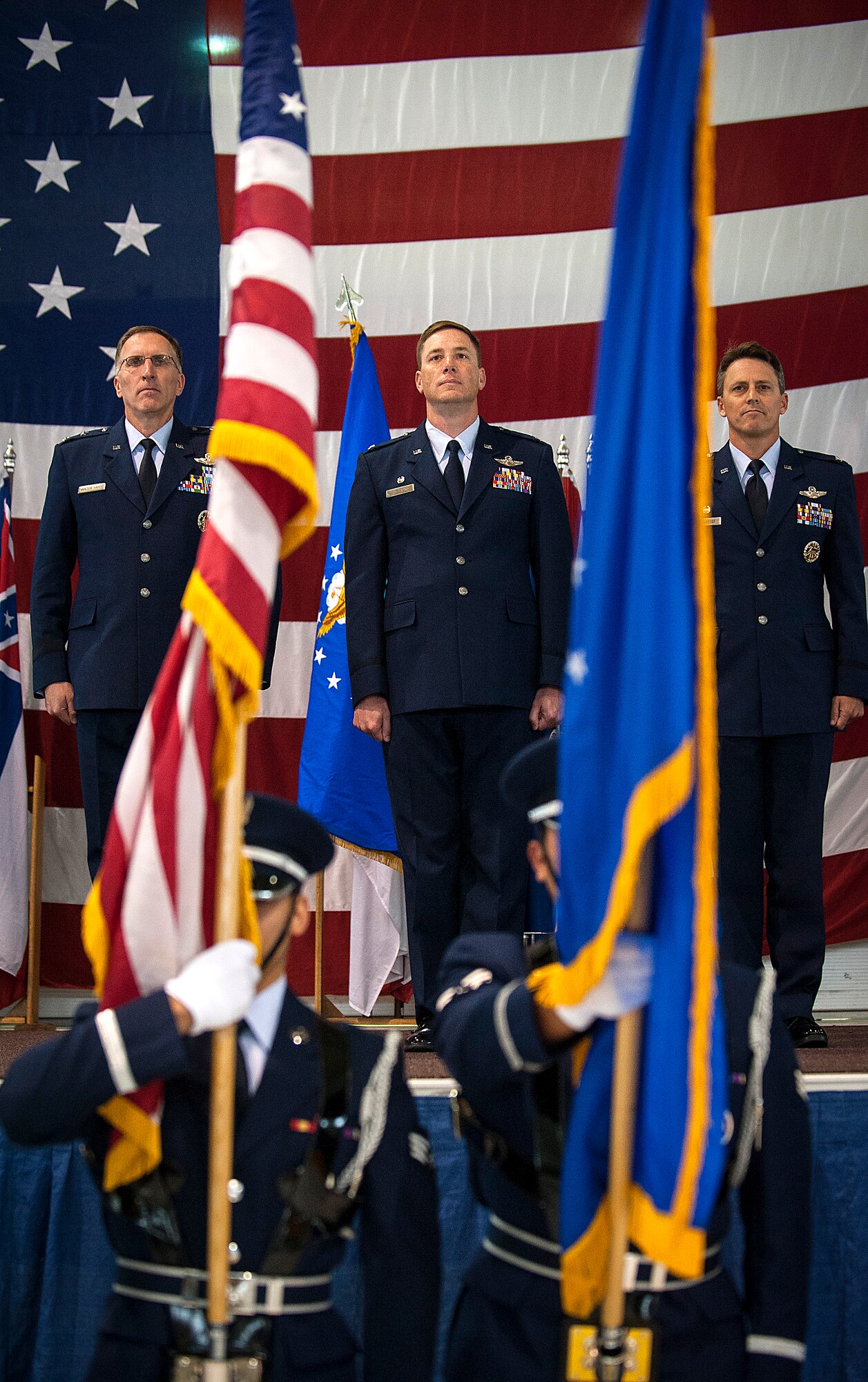 (from left to right) Maj. Gen. Scott Vander Hamm, 8th Air Force commander, Col. Alex Mezynski and Col. Jason Armagost, stand at attention for the presentation of the colors during the 5th Bomb Wing  Change of Command ceremony on Minot Air Force Base, N.D., July 14, 2014. During the ceremony Mezynski relinquished command of the 5th Bomb Wing to Armagost. (U.S. Air Force photo/Senior Airman Stephanie Morris)