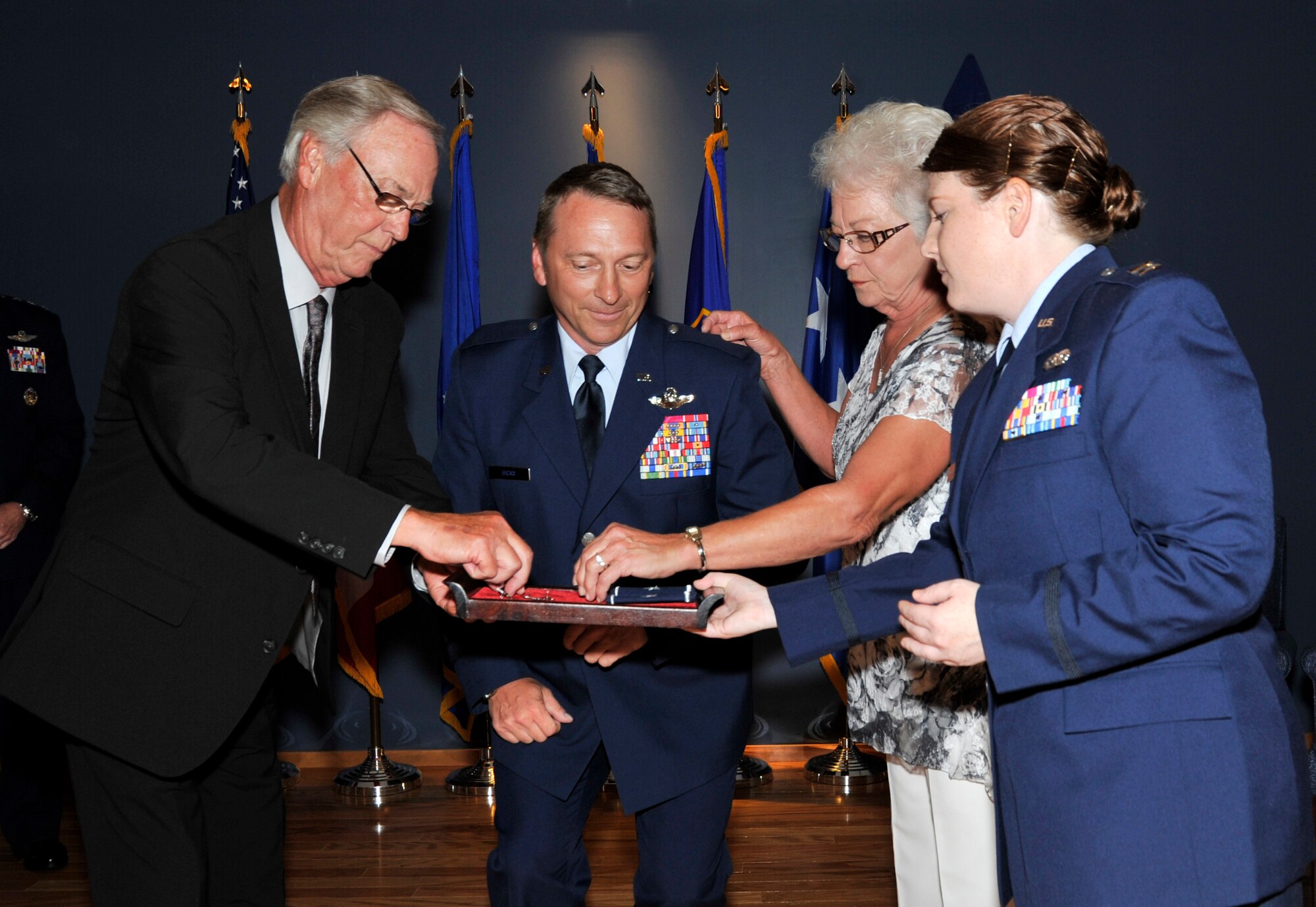 (Left) Wayne Hicks, father of newly promoted Brig. Gen. David Hicks, Air Forces Northern Vice Commander, prepares to pin his son's first star. His mother, Linda French, prepares to pin his other as Capt. Elizabeth Nugent serves as proffer.