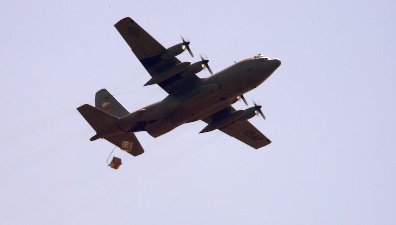 Two container delivery systems are jettisoned out the back of a C-130H Hercules aircraft assigned to the 103rd Airlift Wing during an aerial drop training mission at the "bean bag" drop zone, Westover Air Reserve Base, Chicopee, Massachusetts, on July 12, 2014. The systems being released consist of four barrels filled with water weighing about 700 pounds and a high-velocity parachute tethered to the system allowing for safe descent to the ground. (Air National Guard photo by Tech. Sgt. Joshua Mead/Released)