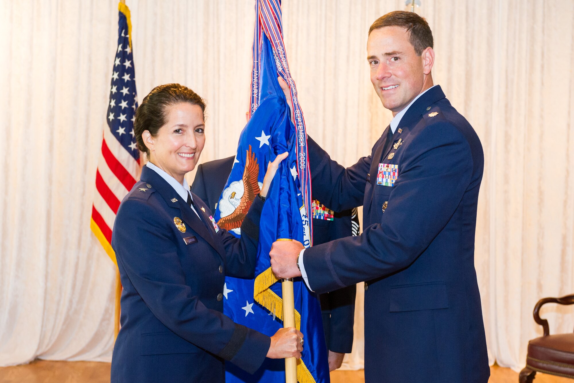 Brig. Gen. Nina Armagno, 45th Space Wing commander, left, presents Lt. Col. Thomas Falzarano, 45th Operations Group commander, with the 45th OG guidon during a change of command ceremony July 10, 2014, at Patrick Air Force Base, Fla. Changes of command are a military tradition representing the transfer of responsibilities from the presiding officials to the upcoming official. (U.S. Air Force photo/Cory Long)