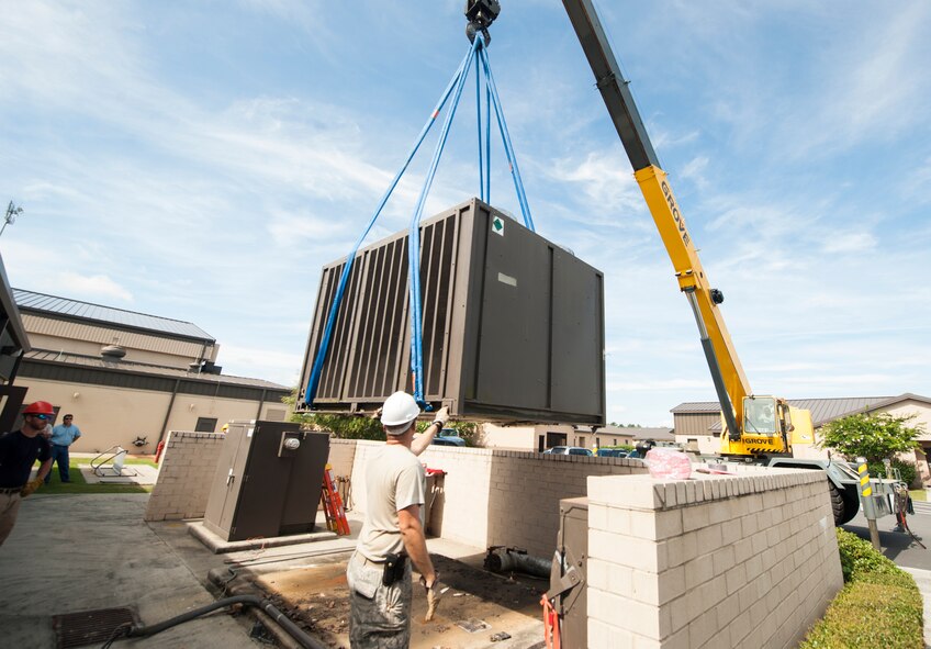 Civil engineer Airmen use a crane to remove an air-conditioning unit at Moody Air Force Base, Ga., July 14, 2014. The engineers replaced this unit after they determined a new one would cost less money in the long run than continually repairing the failing unit. (U.S. Air Force photo by Senior Airman Jarrod Grammel/Released)
