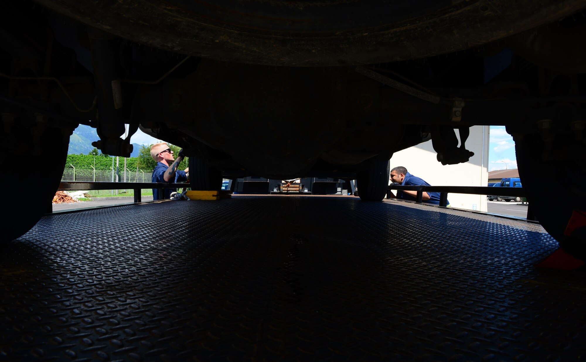 (From left) Airmen 1st Class Vincent Viviano and Micah Cross, 31st Logistics Readiness Squadron vehicle operators, tie down the wheels on an inoperable vehicle, July 15, 2014, at Aviano Air Base, Italy. Since most vehicles cause the tow truck to become top heavy, the response team must tie it down to ensure the balance of the tow truck measures equally and is secured safely. Vehicle management is one of four sections under the 31st Logistics Readiness Squadron responsible for maintaining over 1,000 vehicles on Aviano. (U.S. Air Force photo/Senior Airman Matthew Lotz