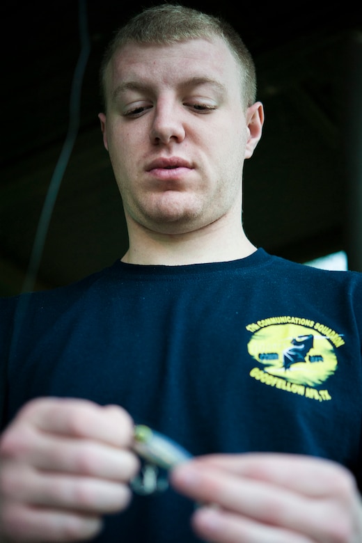 SAN ANGELO, Texas-- Airman 1st Class Travis E. Hill, 17th Communications Squadron focal point technician, ties a lure to a fishing line at the Goodfellow Air Force Base Recreational Camp June 26. Hill has been fishing as a hobby since he was a child and now enjoys it as a way to relieve stress. (U.S. Air Force photo/ Senior Airman Michael Smith)