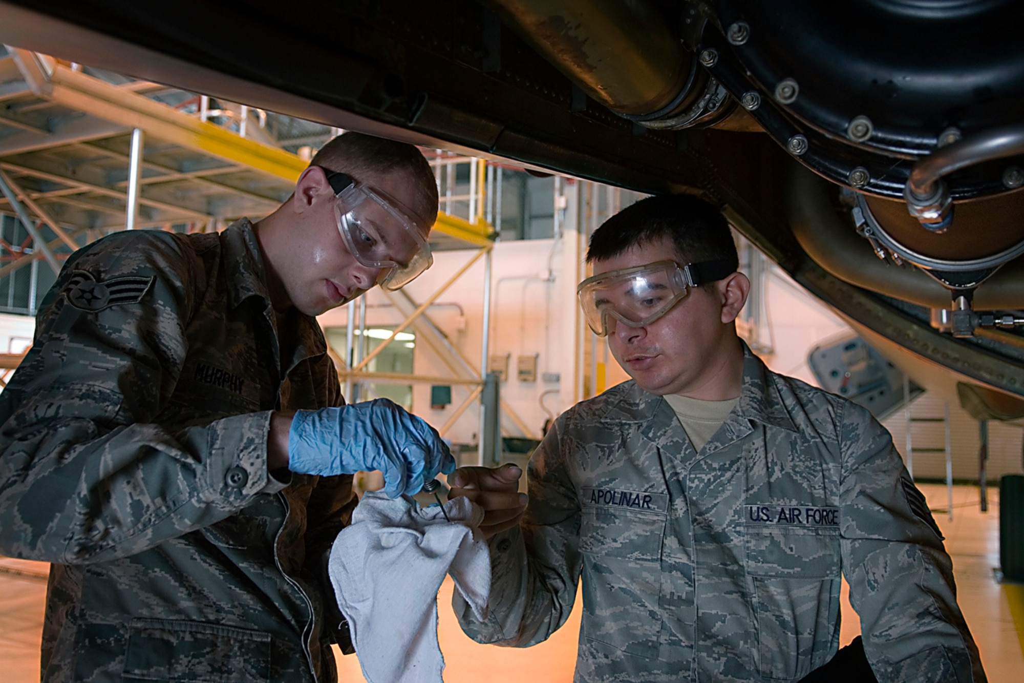 Senior Airman Daniel Apolinar, 434th Aircraft Maintenance Squadron aircraft electric and environmental system journeyman, trains Senior Airman Noah Murphy, 434th Aircraft Maintenance Squadron crew chief, on the proper procedures for changing air cycle machine oil on a KC-135R Stratotanker at Grissom Air Reserve Base, Ind., July 12, 2014. An ACM is a refrigeration unit of an environmental control system on the KC-135 used to provide cabin ventilation. (U.S. Air Force photo/Staff Sgt. Ben Mota)