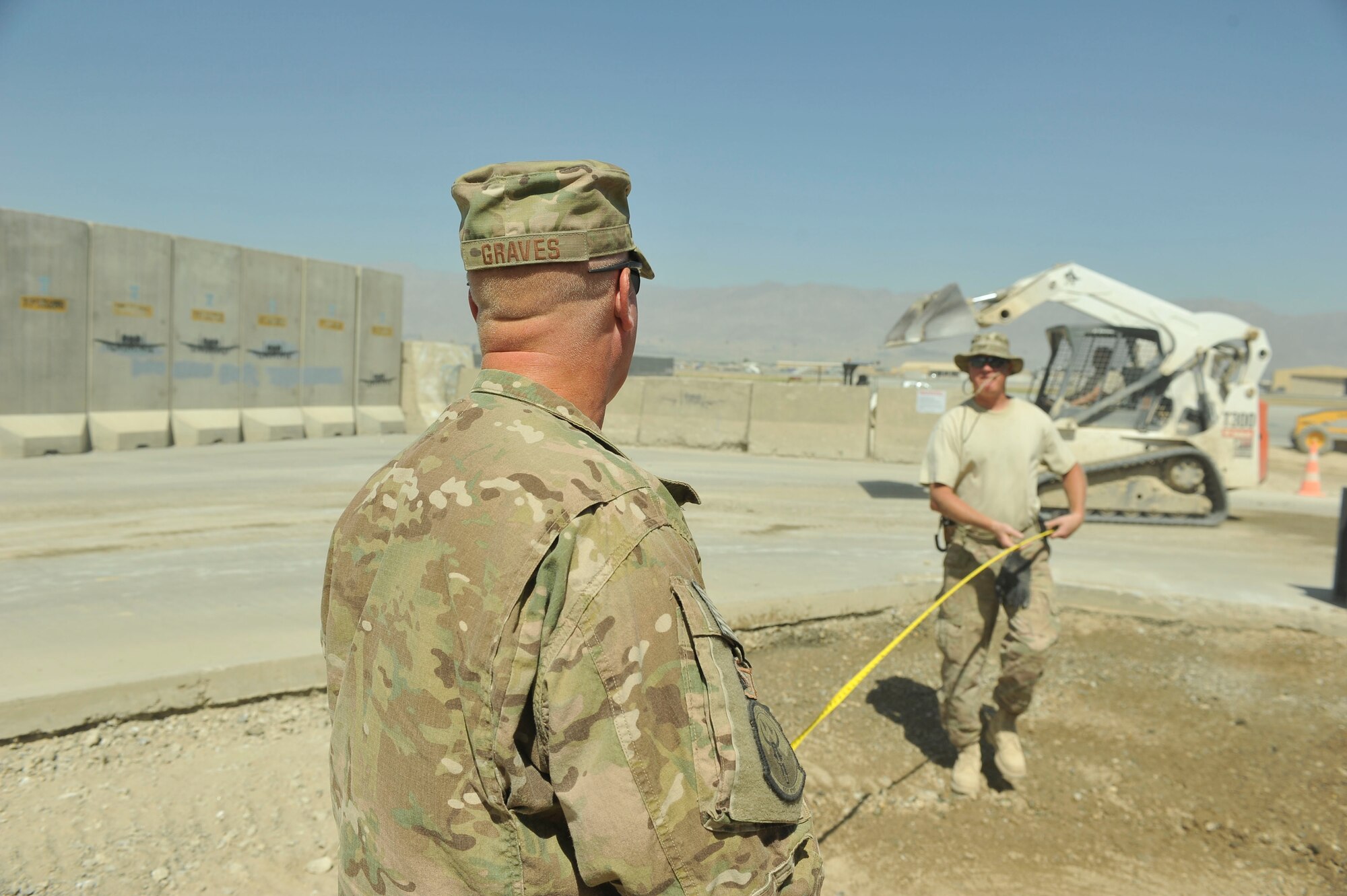 U.S. Air Force Master Sgt. Jeremiah Graves (left), 455th Expeditionary Civil Engineer Squadron heavy equipment supervisor, and Master Sgt. Joshua Graves, 455th ECES project manager, conduct measurements for a project at Bagram Airfield, Afghanistan July 1, 2014. Joshua and Jeremiah, identical twins from Duluth, Minnesota are deployed from the Air National Guard’s 148th Fighter Wing, Duluth, Minnesota. (U.S. Air Force photo by Airman 1st Class Bobby Cummings/Released))