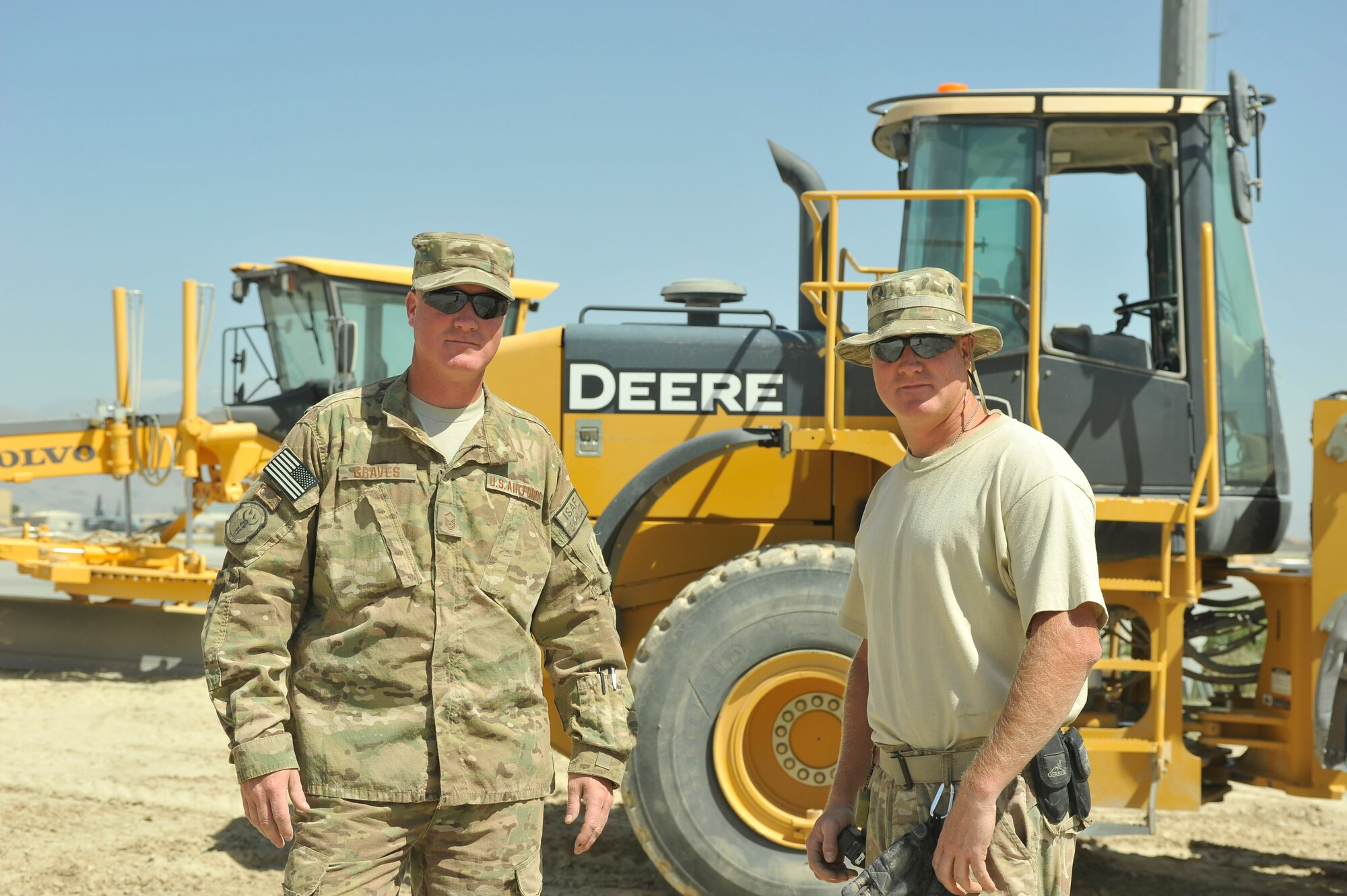 U.S. Air Force Master Sgt. Jeremiah Graves (left), 455th Expeditionary Civil Engineer Squadron heavy equipment supervisor, and Master Sgt. Joshua Graves, 455th ECES project manager stand in front of a bulldozer together at Bagram Airfield, Afghanistan July 1, 2014. Joshua and Jeremiah, two brothers from Duluth, Minnesota are deployed from the Air National guards’ 148th Fighter Wing, Duluth, Minnesota. (U.S. Air Force photo by Airman 1st Class Bobby Cummings/Released)