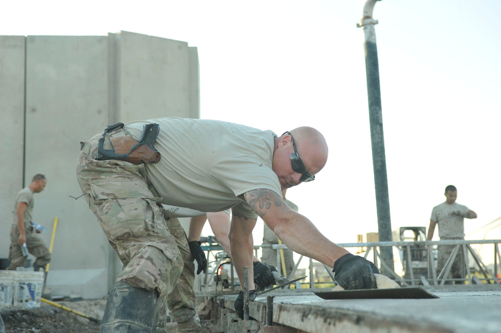 U.S. Air Force Master Sgt. Joshua Graves, 455th Expeditionary Civil Engineer Squadron project manager, levels concrete near Echo ramp at Bagram Airfield, Afghanistan July 9, 2014. Graves is from Duluth, Minnesota and is deployed from the Air National guards' 148th Fighter Wing, Duluth, Minnesota. (U.S. Air Force photo by Airman 1st Class Bobby Cummings/Released) 