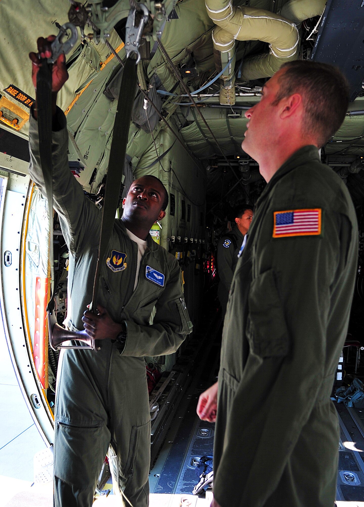 U.S. Air Force Airman 1st Class Ralph Colas, left, 37th Airlift Squadron, prepares a C-130J Super Hercules for a personnel drop at Powidz Air Base, Poland July 8, 2014. The crew prepared the aircraft for 55 U.S. Army soldiers from 1-91 Cavalry Regiment, 173rd Infantry Brigade Combat Team (Airborne), Grafenwoehr, Germany. They prepare the aircraft by setting up enough seats for passengers, setting anchor cables and retrieval systems. (U.S. Air Force photo by Senior Airman Christine Griffiths/Released)