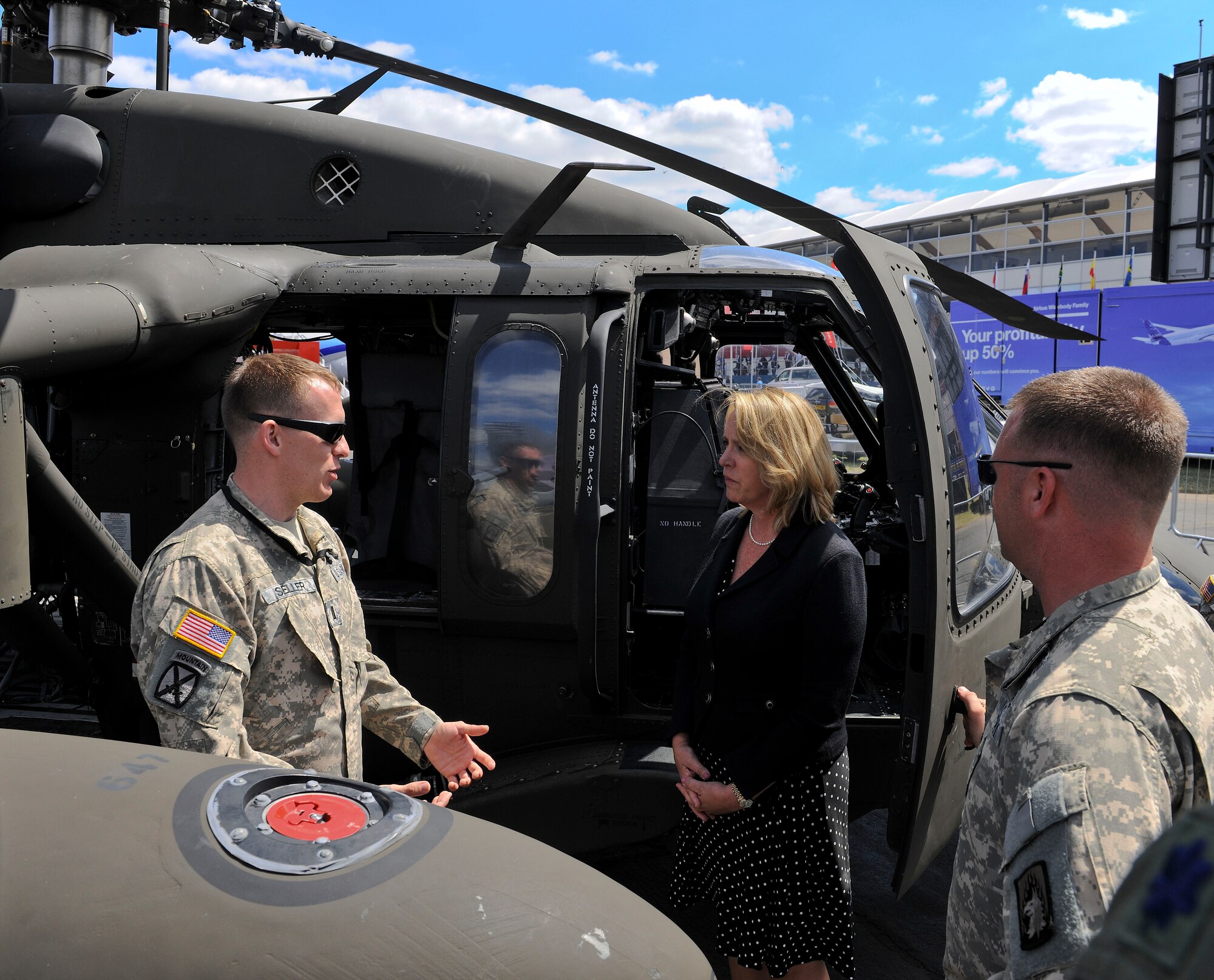 1st Lt Hahns Seller, Alpha Company, 1-214 Combat Aviation Brigade UH-60 Blackhawk pilot, briefs Secretary of the Air Force Deborah Lee James on the aircraft's capabilities at Farnborough International Airshow, England, July 14, 2014.  Secretary James, attending her first Farnborough International Airshow as Secretary of the Air Force, met with military, international and industry members to further partnerships and demonstrate the Air Force’s continued commitment to security and international cooperation. (U.S. Air Force photo Senior Airman Micaiah Anthony)